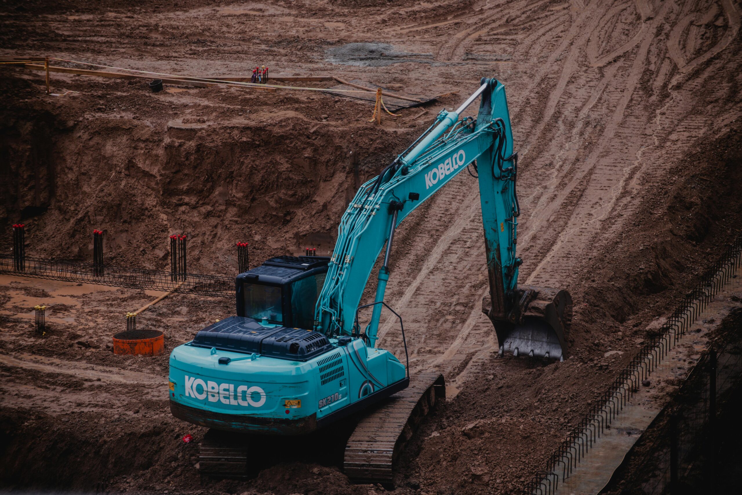 Blue excavator digging a pit at a construction site in Vilnius, Lithuania.